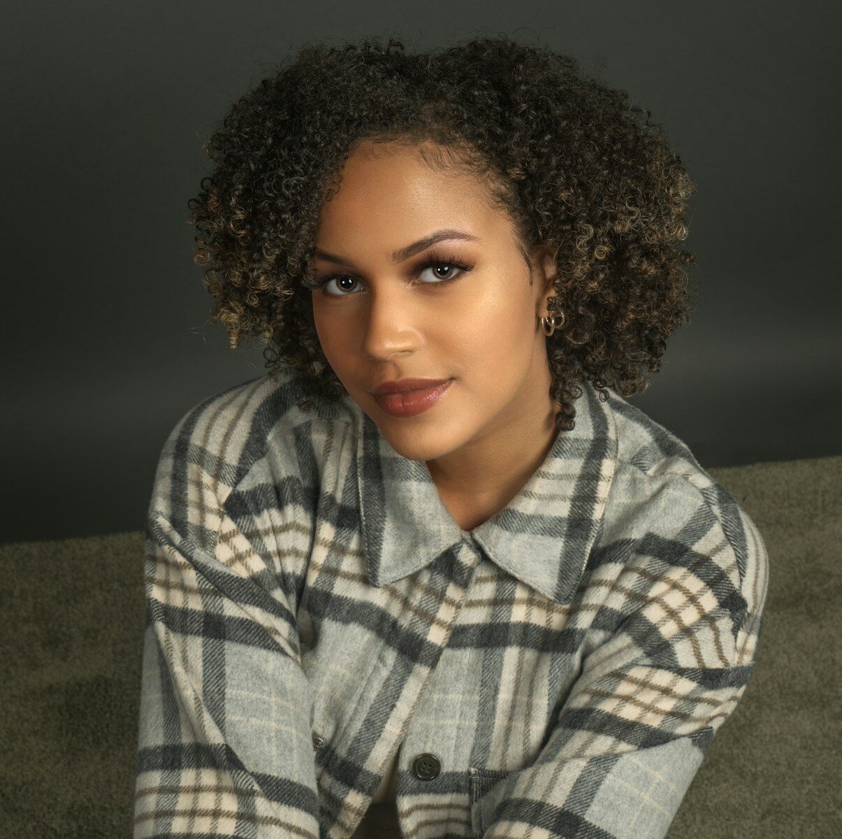 a close up of a person wearing a plaid shirt